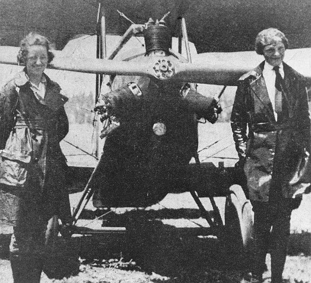 Amelia and Neta Snook posing in front of an airplane