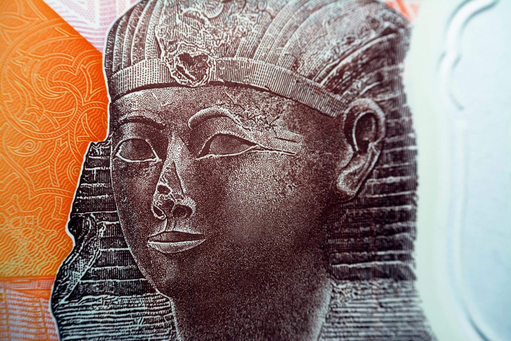 Queen Hatshepsut closeup view from the reverse side of the new first Egyptian 10 LE EGP ten pounds plastic polymer banknote with a part of the great pyramid of Giza Khufu pyramid, selective focus